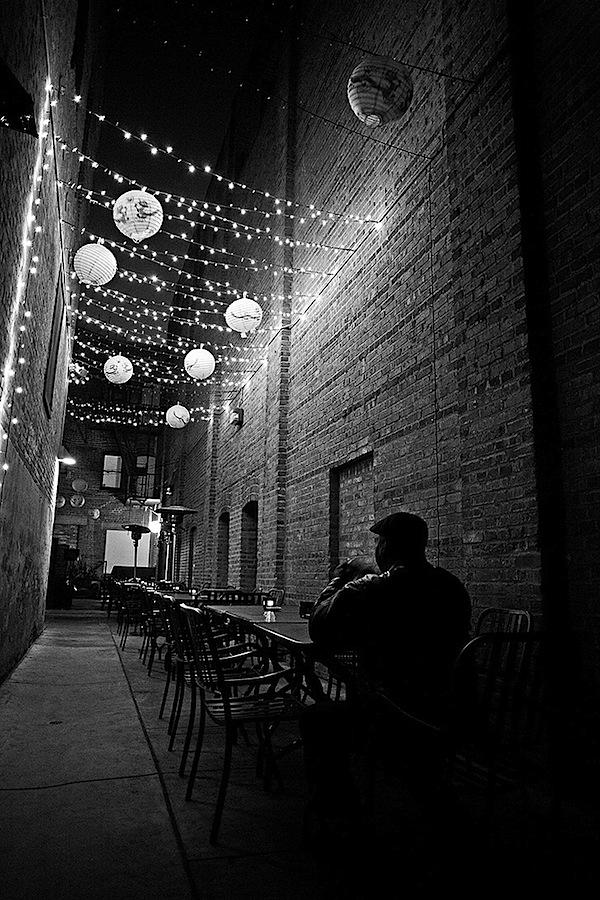 man dining in the night in an alley