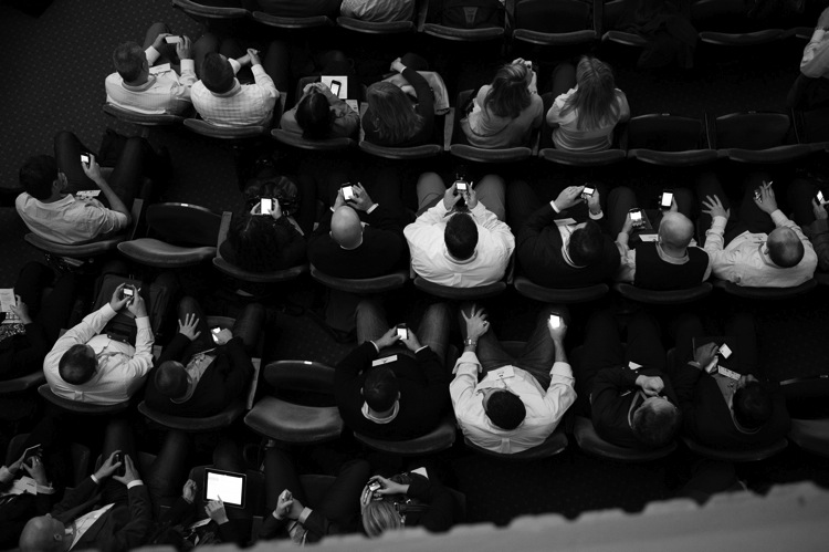 people in chairs with smartphones